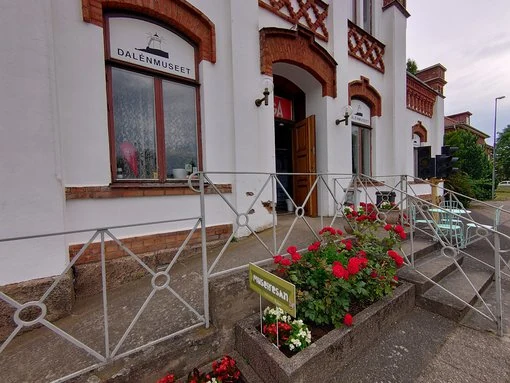 Entrén till Dalénmuseet i Stenstorp, med vackert bevarad arkitektur och blommor som välkomnar besökare.