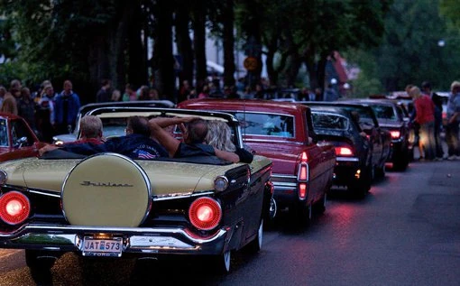 En gul cabriolet rullar genom Falköping med människor som njuter av kvällen och cruising.